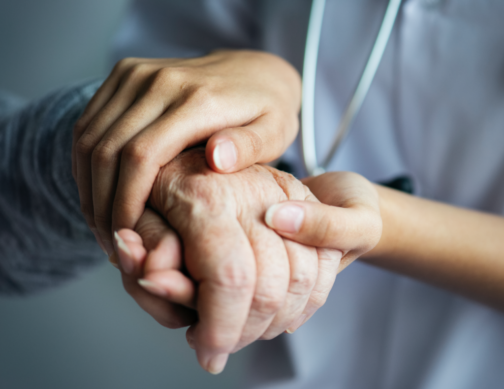Hands of carer and service user touching